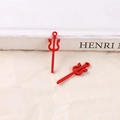 Close-up of red alloy trident charms for Halloween DIY jewelry making on white paper - Red Trident