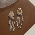 Detailed macro view of crystal flower tassel earrings with beaded petal design - White