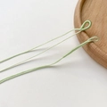 Nahaufnahme der hellgrünen geflochtenen Schnur mit gewebter Schlaufe für DIY-Schmuck - Hellgrün