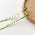 Detailansicht der grünen geflochtenen Schnüre mit handgewickelten Schlaufen für DIY-Schmuck - Grasgrün
