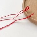Makroaufnahme von roten geflochtenen Schmuckschnüren mit handgefertigten Schlaufenringen für DIY - Rot