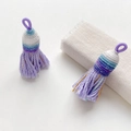 Macro detail of braided ethnic tassels with purple silk threads and subtle gold accents - Style 18