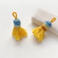 Primer plano de borlas tejidas amarillas hechas a mano con nudos decorativos estilo étnico - Estilo 10
