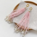 Detail view of pink beaded fringe tassel pendant with pearl accents on rustic fabric - Single Piece / Light Pink