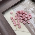 Detailed view of pink Czech glass flower beads on vintage newspaper for DIY craft - 5# 6-Petal Flower - Pink Silver-Edged