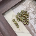 Macro detail of Czech glass flower beads with antique bronze and turquoise patina finish - 3# 6-Petal Flower - Transparent Green