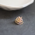 Macro shot of a hollow golden wheel-shaped jewelry pendant on textured grey stone - Fine Hollow Wheel Style (6#)
