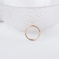 Nahaufnahme eines minimalistischen goldenen Ohrring-Anhängers auf Glasfläche - Minimalistischer dünner runder Ring (4#)