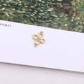 Close-up of golden metal four-petal flower connector with dual loops for DIY jewelry - Four-petal Hollow Flower Double Loop Connector (15#)
