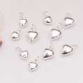 Polished 14K gold-filled solid heart pendants set of nine on white textured fabric background - 7mm / Silver