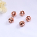Macro view of five rose gold hollow beads with inlaid zircons for DIY jewelry making - Rose Gold Color (Color Retention)