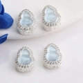 Detailed view of hollow filigree 14K gold wulu pendants with blue stones and white zircons - Silver (Inlaid Blue)