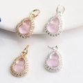Macro view of 14K gold gourd charms with pink gemstones and pavé zircon detailing - Purple Zircon Gourd