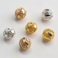 Detailed macro of 10mm hollow gold and silver filigree metal spacer beads with vine patterns - Scroll Vine Style (Style No.5)