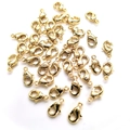 Macro view of scattered 14k gold-filled lobster clasps for DIY jewelry making - 12mm / 14K Gold