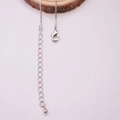 Detailed macro of a 14K gold filled box chain featuring a lobster clasp and teardrop charm - White Gold