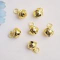 Polished 14K gold plated bell charms for jewelry making on light pink fabric background - Round with Bells / 18K Gold