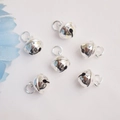 Set of six shiny silver bell charms for DIY jewelry making on white fabric background - Round with Bells / Silver