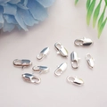 Detailed view of silver lobster clasps for DIY jewelry making on white textured fabric - 801 Fish Tail Clasp 10mm / White Gold