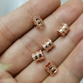 Five rose gold faceted cylinder spacer beads for DIY jewelry bracelets on a finger - Rose Gold