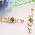 Detail van 14K vergulde vlinder sieraadsluiting met zirkonia en een groene edelsteen - Smaragd Stijl / Roségoud