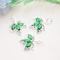 Detailed view of three maple leaf pendants with emerald green zircons on beige fabric - Silver Color (Green Zirconia Maple)