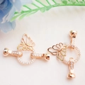 Macro shot of 14K gold butterfly clasp with cubic zirconia and round pearl connector - Butterfly Design / Rose Gold