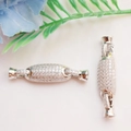 Macro-opname van zilveren vlindersluiting met zirkonia voor het maken van sieraden - Pavé Cilinder Stijl / Witgoud