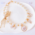 Close-up of pearl pet necklace with gold crown charms and a mesh bow on a tray - XS / White Necklace