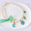 Detail of pet pearl necklace with green mesh bow and enamel star moon charms - XS / Green Necklace