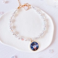 Detail of pearl pet collar with starry night cat pendant and heart charm on white tile - Black Hat Cat Pendant Necklace