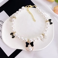 Detail of luxury pet pearl necklace with black enamel bow and sparkling rhinestone accents - XS / Black Pearl Bow Necklace