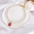 Close-up of vintage pet pearl necklace featuring a red rose pendant and gold clasp - XS / Red Rose Necklace