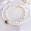 Detail of a pearl pet necklace with a heart pendant featuring a black camellia flower - XS / Heart Camellia Necklace
