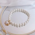 Elegant white pearl pet necklace with heart pendant and gold trim on silk background - Heart Nude