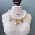 Elegant pet pearl necklace with gold peanut and Chinese luck charms on display stand - Peanut Trio