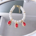 Double row pearl cat collar featuring oval red gemstone pendants and gold clasp - Ruby Red