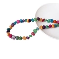 Bunte unregelmäßige Natursteinperlen für DIY-Schmuck auf weißem Porzellanteller - Mehrfarbig