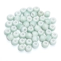 Macro shot of light green glazed ceramic beads with white inner hole for DIY jewelry making - Pale Green Glazed