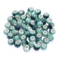 Macro shot of glazed ceramic round beads with teal and cream gradient for DIY jewelry making - Teal Gradient