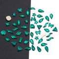 Macro shot of emerald green flatback glass crystals in various shapes for nail art DIY - Peacock Green - Irregular