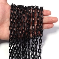 Glossy black acrylic chain links being held for DIY jewelry and bag accessories - Black
