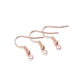 Gros plan de trois crochets d'oreilles en or rose avec ressort et boucle pour bijoux DIY - 200 pièces/paquet / Or rose