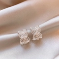 Vista detallada de elegantes pendientes plateados en forma de C con diseño floral calado - Aguja de plata / Plateado