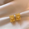 Primer plano exquisito de pendientes de flores caladas doradas con circones en raso - Aguja de plata / Dorado