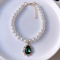 Detailed macro view of white pearl pet necklace with a green waterdrop gemstone pendant - Dark Green