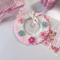 Dettaglio del collare per animali intrecciato a mano con pizzo bianco e fiori colorati - Rosa