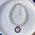 Detail of pet pearl necklace with black enamel camellia pendant and golden clasp - White Rose