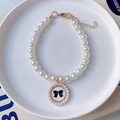 Detalle de collar de perlas para mascotas con cierre dorado y colgante de lazo negro - Talla XS (0,5-1,5 kg) / Lazo Negro