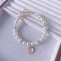 Close-up of pearl pet necklace with pink gemstone pendant and golden lobster clasp - Light Pink Necklace